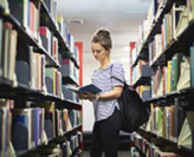 Female student reading book in library. CEEHE Library