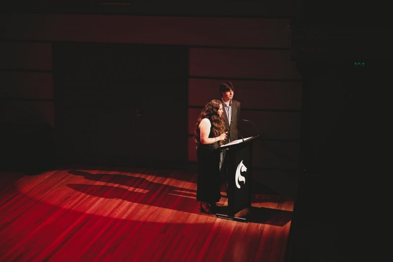 Two people speaking on a stage