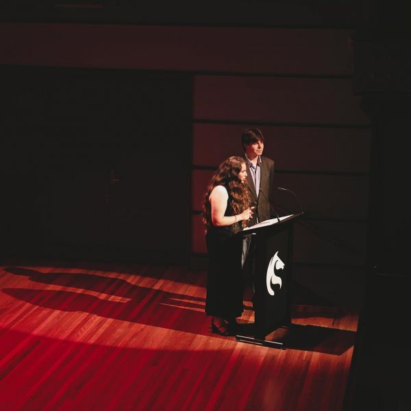 Two people speaking on a stage
