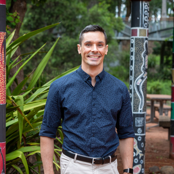 Headshot of Guy Cameron outdoors with Indigenous artwork in the background