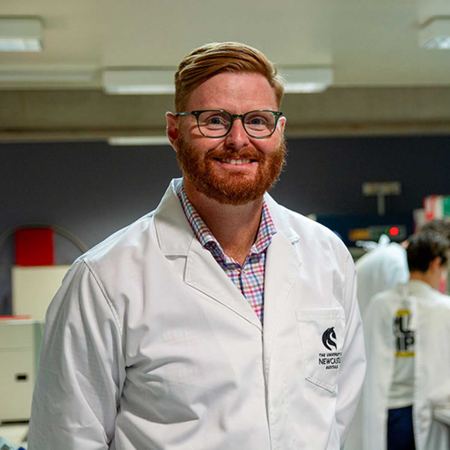 Man with glasses standing in a white laboratory coat