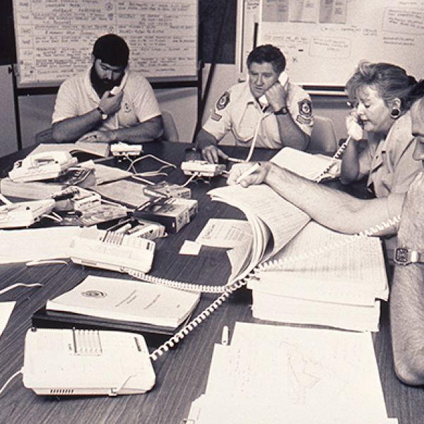 Several people seated at desks answering telephones in an emergency call centre set up in response to the 1989 Newcastle earthquake.