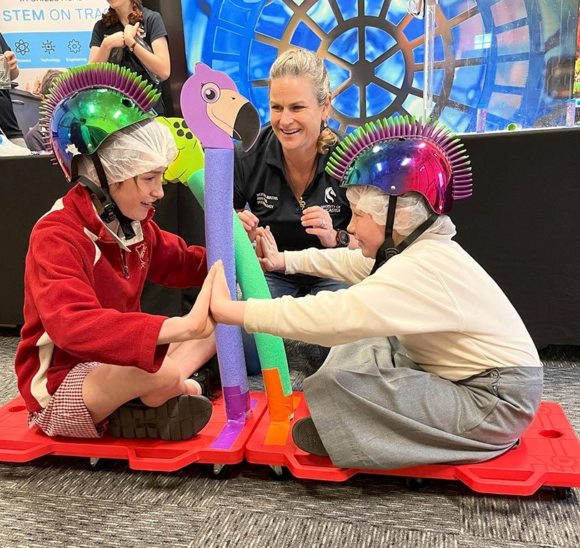 Presenter with 2 students on trolleys