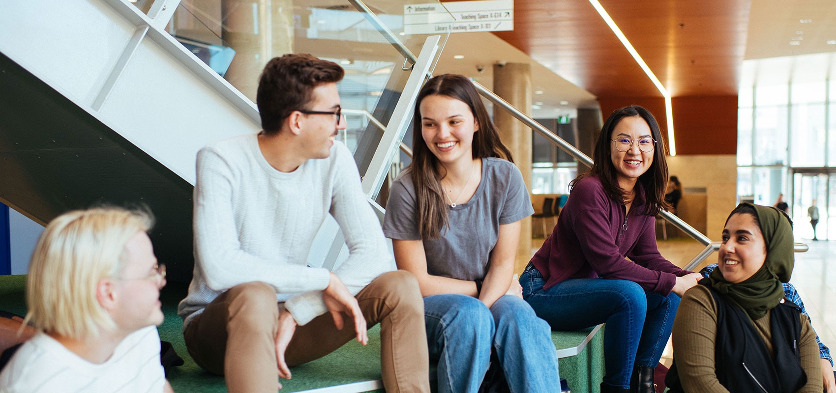 Student sitting in a university campus smiling