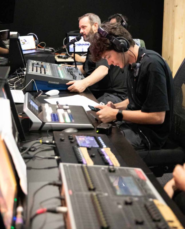 A group of people using backstage audio equipment