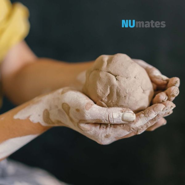Decorative image of hands holding clay