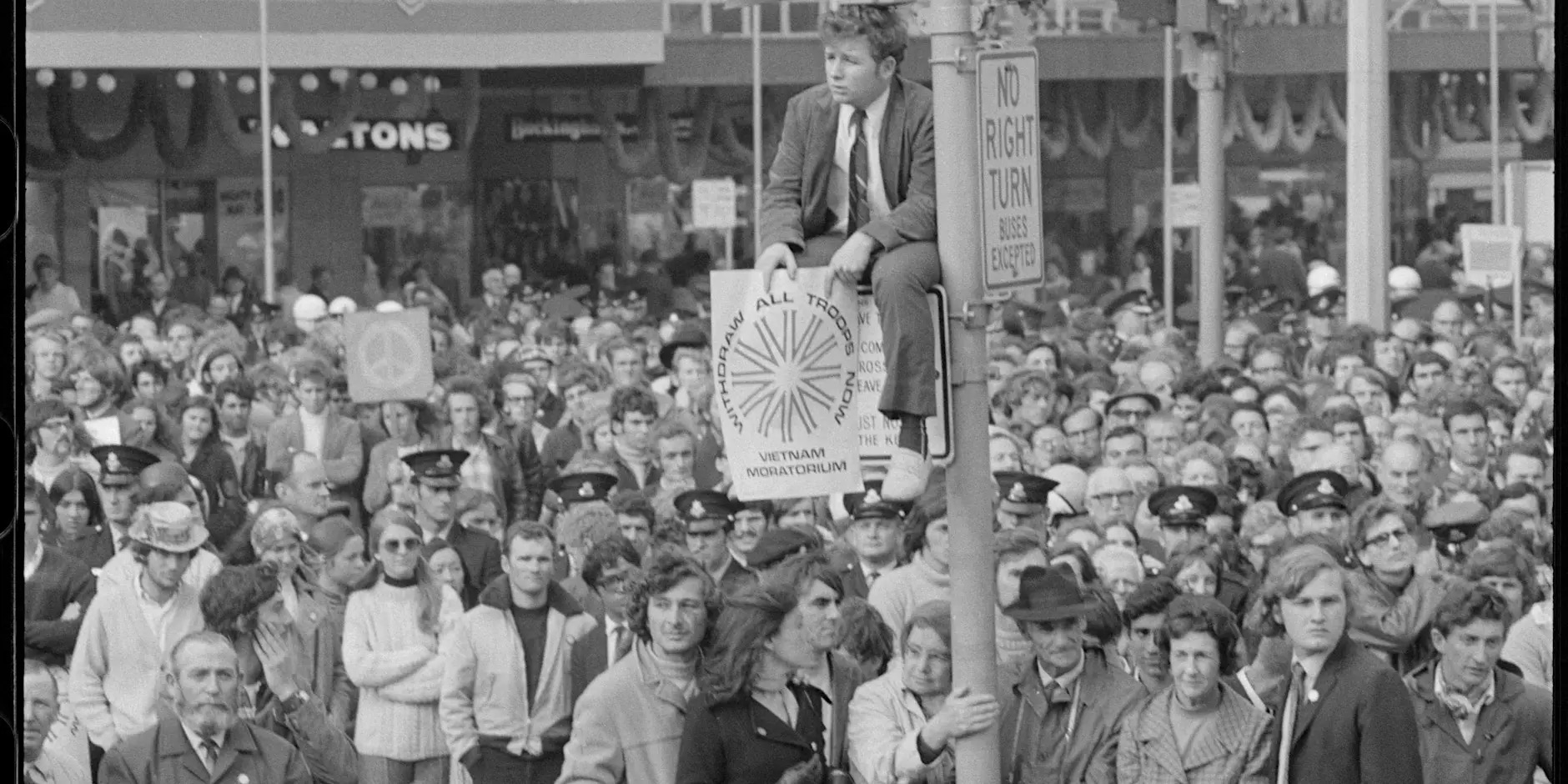 a black and white historical photograph of crowds and posters during a protest