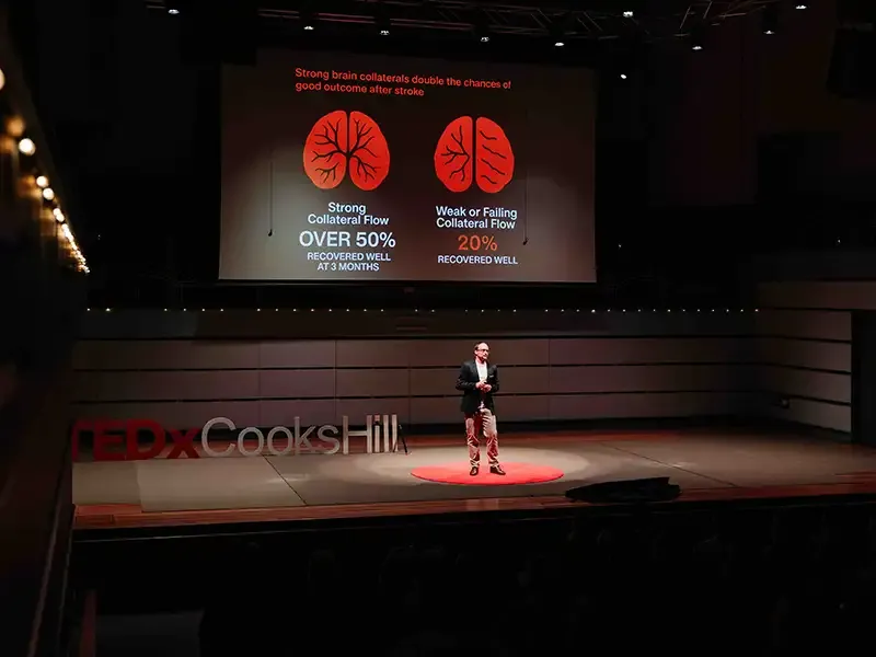Dr Daniel Beard speaking on stage TEDx Cooks Hill, 2025