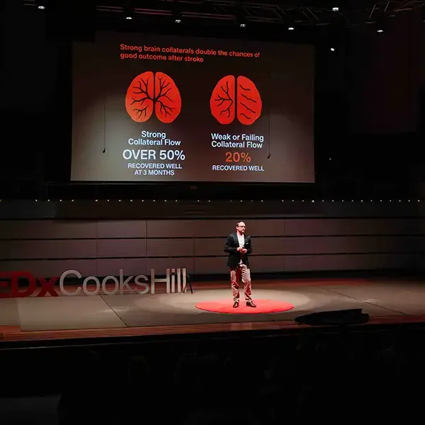 Dr Daniel Beard speaking on stage TEDx Cooks Hill, 2025