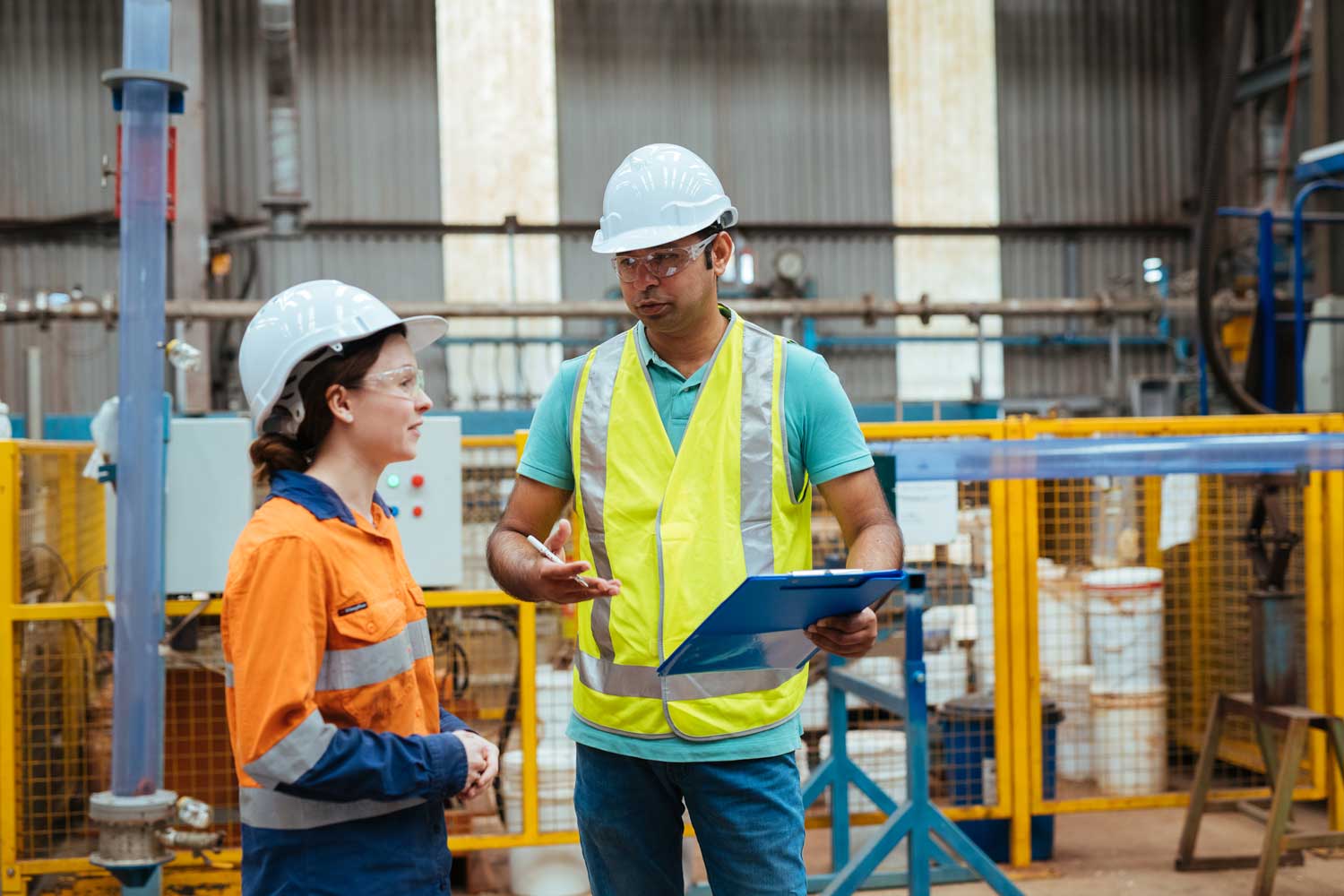 Three people walking through the university, holding coffee and paperwork.
