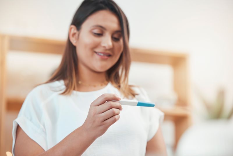 Woman looking at a pregnancy test and smiling