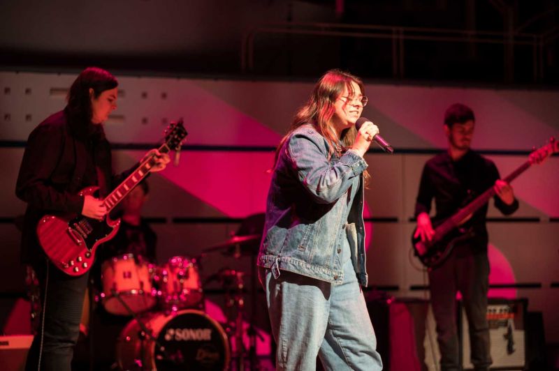 Two guitarists, a drummer and a singer performing on stage