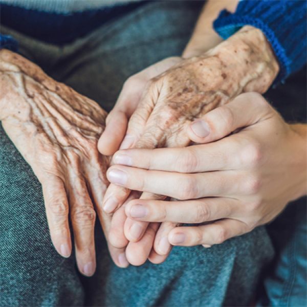 AAG Conference web A pair of young hands gently holding an elderly person's hands.