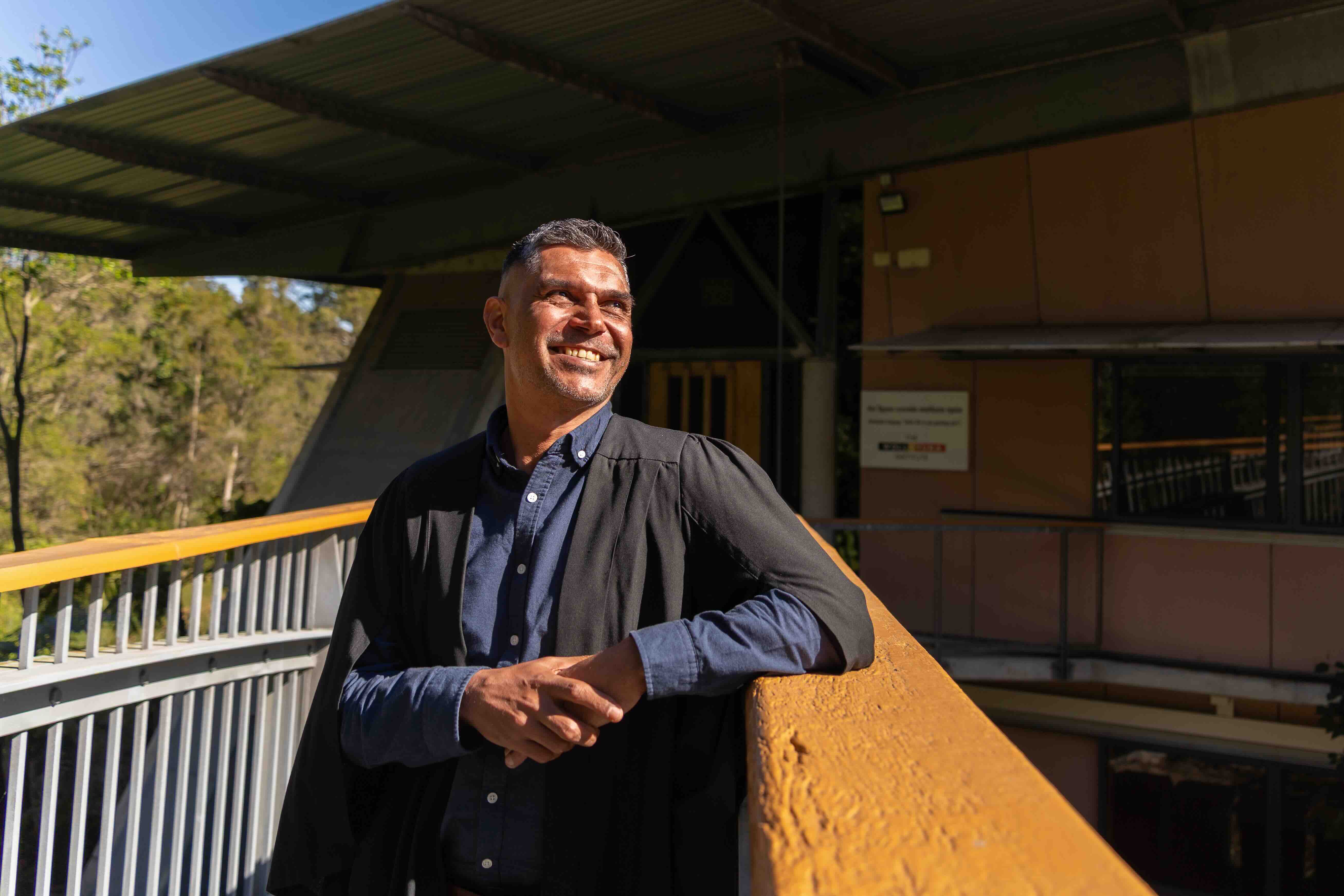 Raymond Bud Kelly Junior stands at the entrance to the Wollotuka building smiling
